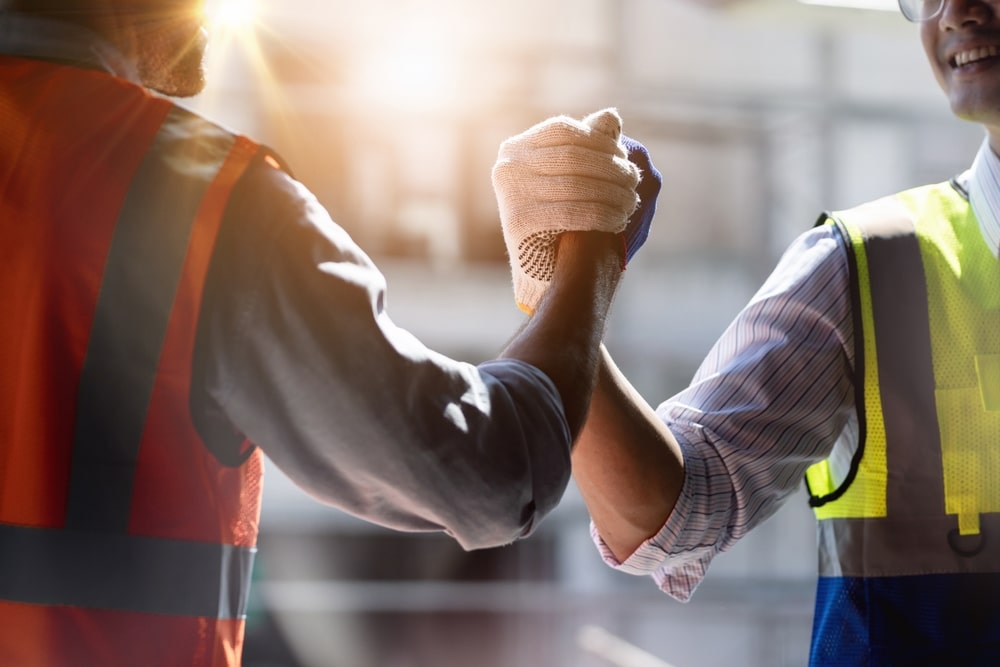 Two Men In Vests Shaking Hands