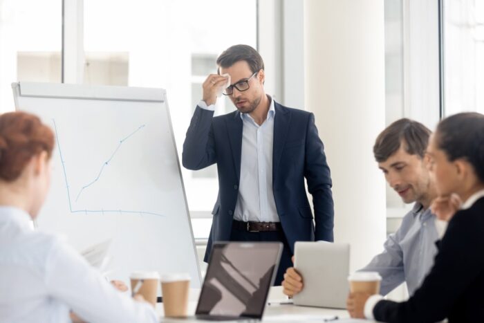 Nervous sweaty public speaker sweating wiping sweat afraid or speaking at presentation, stressed worried businessman presenter feel fear panic attack anxious about speech in front of business people