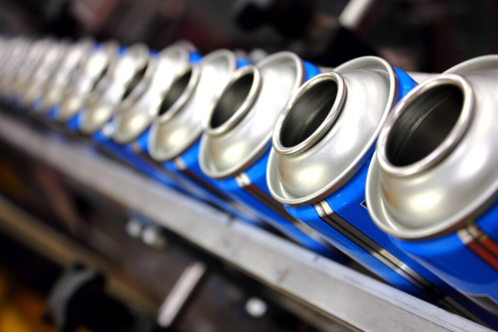 Aerosol manufacturing factory showing empty cans on the production line