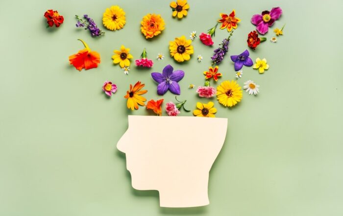 Human head symbol and flowers on blue background. World mental health day concept