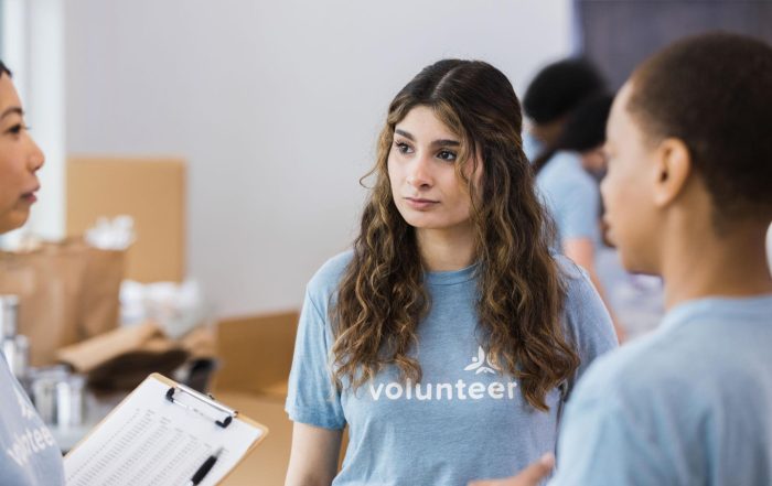 Volunteer coordinator having a calm conversation with volunteers to address conflict and improve teamwork in a nonprofit organization.